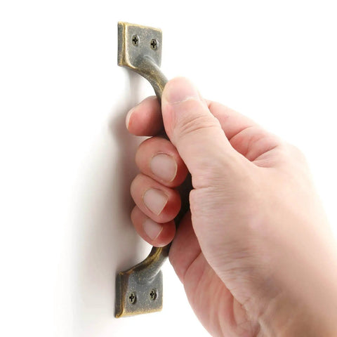 Hand holding Rustic Bronze Cabinet Handles Set Of 8 Five And A Half Inch Curved Metal Drawer Pulls With Screws