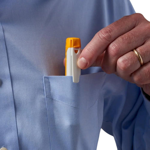 Fluke Networks FIBERLERT-125 fiber optic tester in orange and white being placed into a shirt pocket.