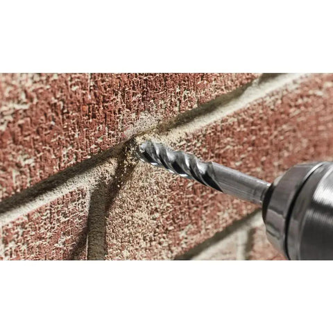 Fast Spiral Rotary Masonry Drill Bit With Carbide Head For Long Life And Quick Material Removal In Brick Block And Concrete Three Quarters Of An Inch By Four By Six Inches Bosch BM2019 drilling into a brick wall