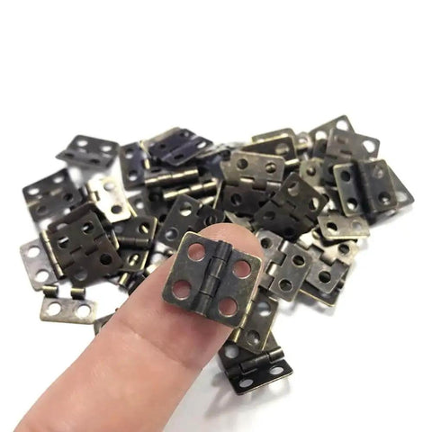 Close-up of vintage style mini copper hinges set with 50 pieces and 200 nails for wooden boxes, jewelry chests, and cabinets.