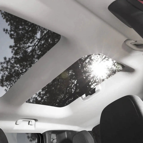 Car interior with sun shining through sunroof, showcasing gray mesh headliner fabric with foam backing for roof replacement.
