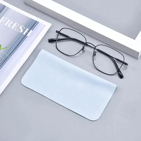 Eyeglass and light blue microfiber eyeglass cleaning cloth, 230GSM thickened double-sided, placed on a gray surface.