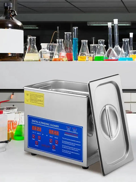 Front view of a stainless steel ultrasonic cleaner with blue digital control panel and open lid on lab bench.