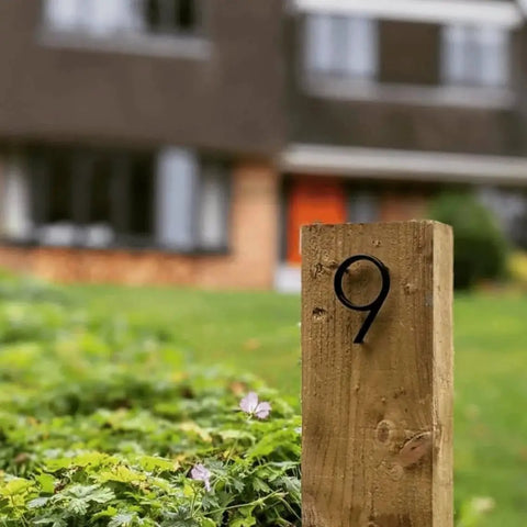 5 Inch Stainless Steel Floating House Number With Nail Kit Coated Black 911 Sign installed on wooden post in garden