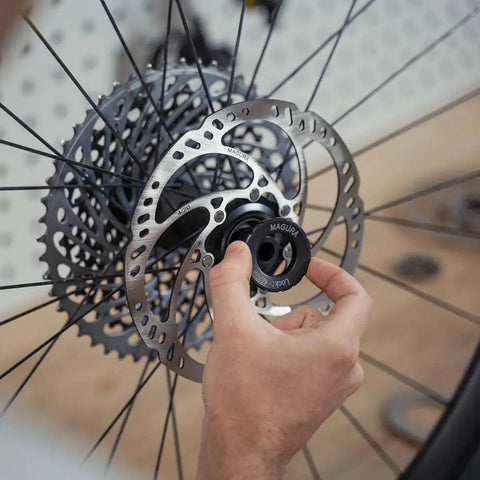 Magura MDR-C 203mm brake rotor; silver perforated disc with black center-lock ring (close-up view).