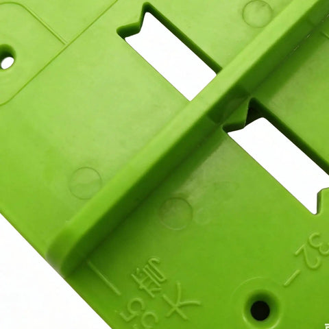 Close-up view of 35mm Hinge Template Router Jig For Cabinets Drawers And Furniture Doors With Pro Grade Durable Aluminum Guide And Adjustable Stops Precision Concealed Hinge Boring Jig For Woodworking Installations in green plastic.