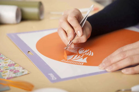 Person using tweezers from Go-To 5-Piece Craft Tool Set for Precision Lifts Snips Burnish and Weed by Cricut to weed vinyl design