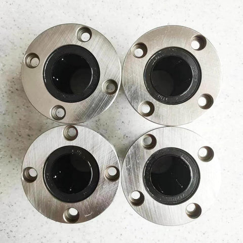 Top view of four Flanged Linear Bearing Bushing LMF25UU Chrome Steel SAE 52100 with Rubber Sealed Closure on a white surface.