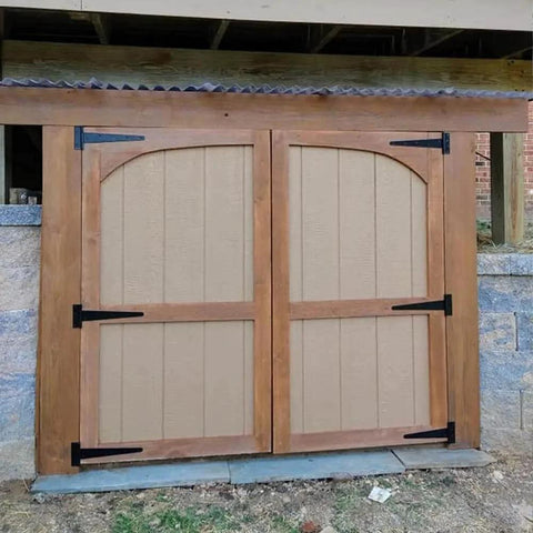 Installed wooden barn doors with black wrought iron 8 Inch T Strap Barn Door Hinges Heavy Duty Gate Hinge Set, rustproof design