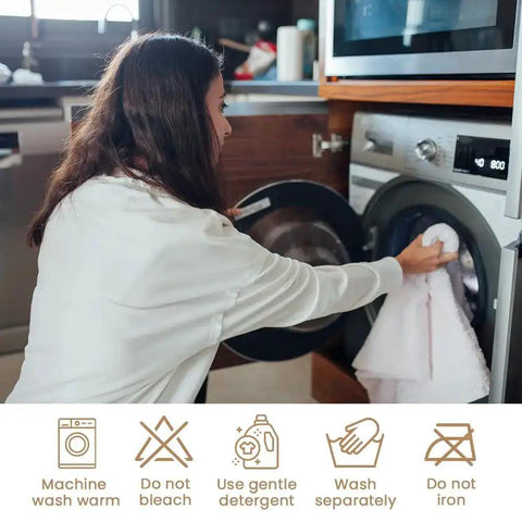 Woman loading white cotton towel into washing machine with laundry care symbols below.