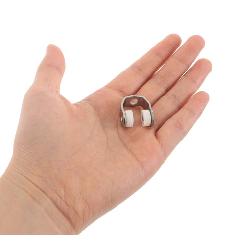 Close-up of 25 Pack Sliding Door Rollers and Metal Track Wheels Kit component in hand, part of Durable DIY Shade Cord Winder Hardware for Home and Office