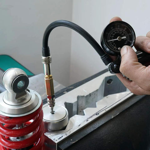 NICECNC nitrogen needle kit with needle head connected to a shock gauge beside a red coil spring suspension.