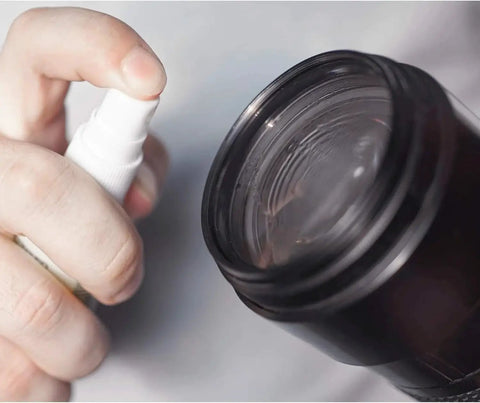 Hand using Clear View Screen And Lens Cleaner For Eyeglasses Laptops Smartphones 1 Gallon on camera lens