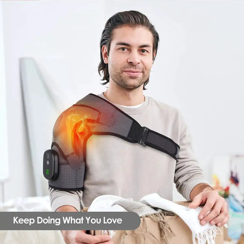 Man using Cozy Heated Shoulder Wrap Massager with cordless design, showcasing fit on right shoulder and adjustable strap in home setting
