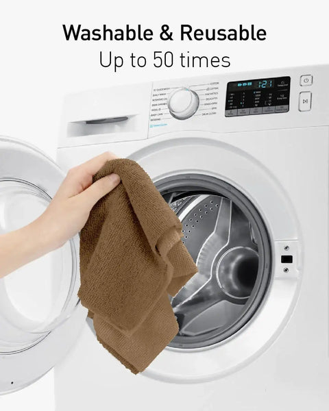 Hand placing Tear-Away Microfiber Cleaning Cloth into washing machine, showcasing reusable 12-inch cloth from 75 pack