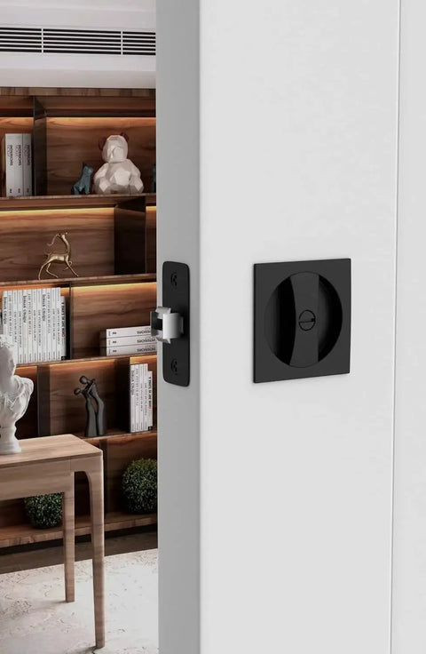 Matte Black Pocket Door Lock Set In Zinc Alloy, 2-3/8 Backset installed on white interior door with square handles.