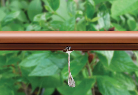Drip irrigation tubing, brown 1/2-inch, inline emitter releasing water