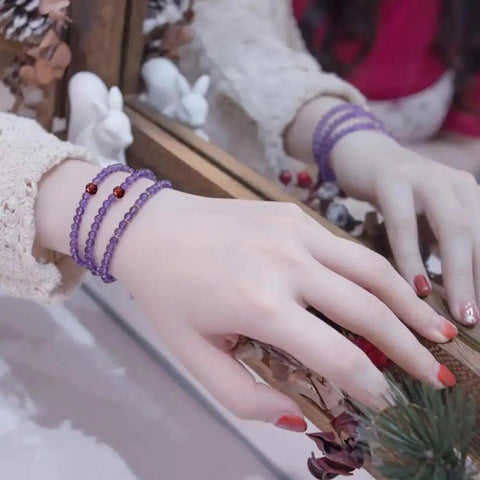 Woman's hand wearing purple bracelet with Approximately 270 Pieces 3mm Natural Faceted Garnet Beads For Jewelry Making.