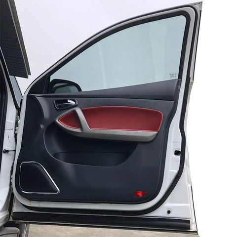Automotive door weather stripping rubber seal on a white car door; black interior panel with red armrest.