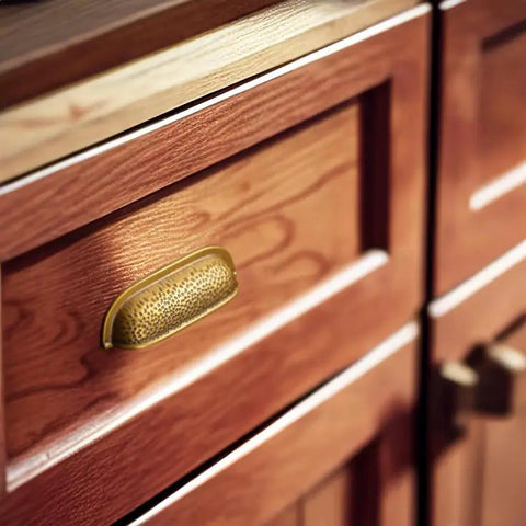 Six Pack 3 Inch Antique Brass Cabinet Cup Pulls With Hand Hammered Texture And Smooth Curved Edges on wooden kitchen drawer