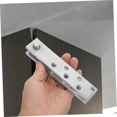 Hand holding 360 Degree Beefy Heavy Duty Concealed Door Hinges Stainless Steel Pivot System for Secret Doors.