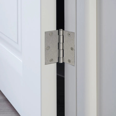 Interior door hinge, satin nickel finish, heavy‑duty steel, installed on white door edge.