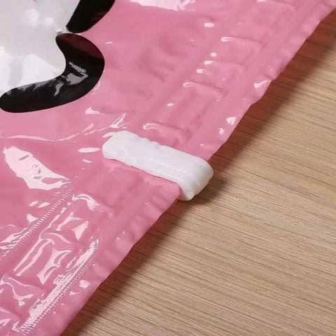 Pink vacuum bag sealed with a white clip for airtight storage, highlighting the 10 Pack Vacuum Bag Clips With Sliding Grip For Tight Seals.