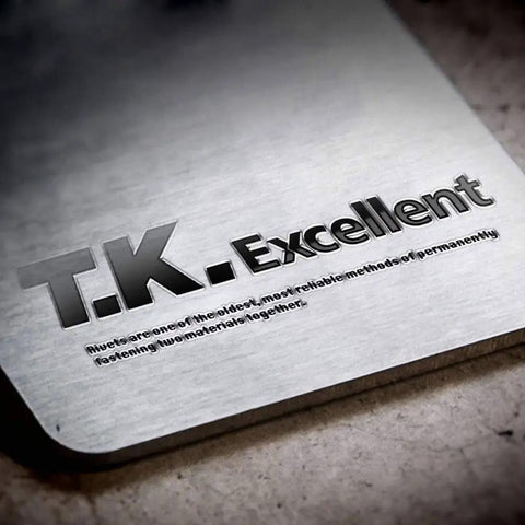 Close-up of T.K. Excellent logo on a metallic surface with engraved text about fastening materials.