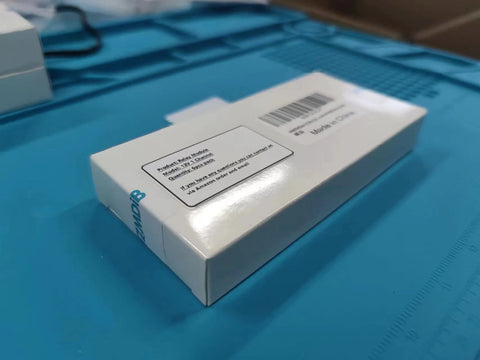 Electronics kit box, Amazon-brand white packaging with barcode label on blue work surface.