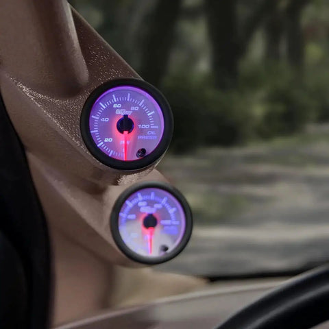 Installed white 7 color oil pressure gauge kit for cars with 0 to 100 PSI readings, red illuminated needle, and clear lens on dashboard.
