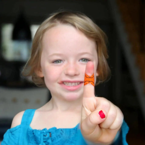 Child showing bandaged finger using Compact First Aid Kit With Medical Grade Adhesive for Quick Field Fixes, small dressings.