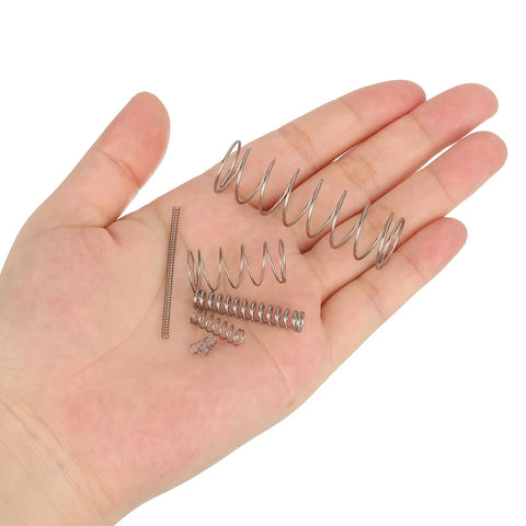 Set of 20 stainless steel compression springs held in hand; silver tone, 2 mm outer diameter, 0.3 mm wire, 40 mm free length.
