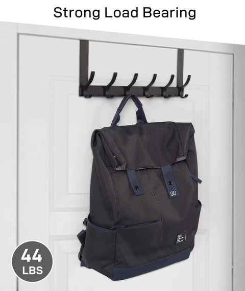 Backpack hanging on a black wall hook with strong load bearing 44 lbs; hooks installed on a white door.