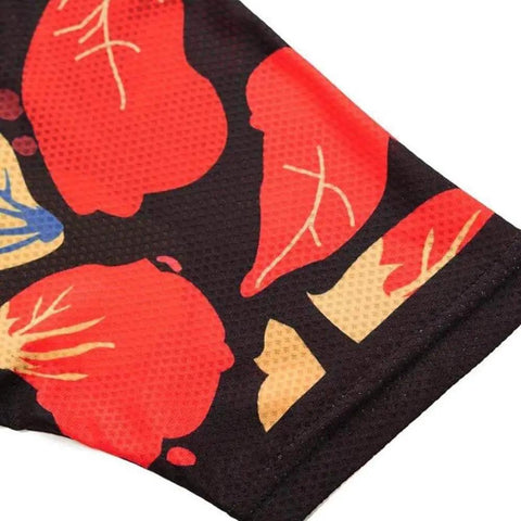 Close-up of a fabric with bold red, orange, and yellow floral pattern on a black background.