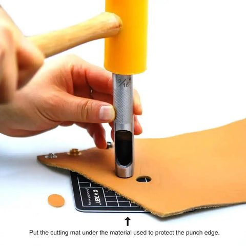 Using 12 Piece Leather Hole Punch Set With Free Cutting Mat on leather with a hammer, showing ergonomic non-slip handles.
