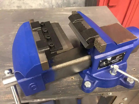 Close-up of a blue 4 Inch Vise Mount Press Brake Bender Attachment for Sheet Metal Cross Slide, mounted on a workbench.