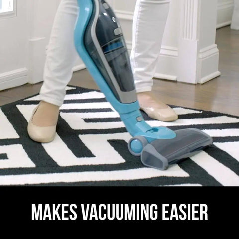 Person vacuuming a white and black patterned rug using a blue vacuum cleaner on hardwood floor with 'Makes Vacuuming Easier' text, emphasizing its use with Felt With Rubber Rug Pad That Grips And Keeps Rugs From Sliding, Slip Resistant Underlayment, 1/8 Inch Thick, 3x5 Feet Area Rug Pad For Hardwood Floors