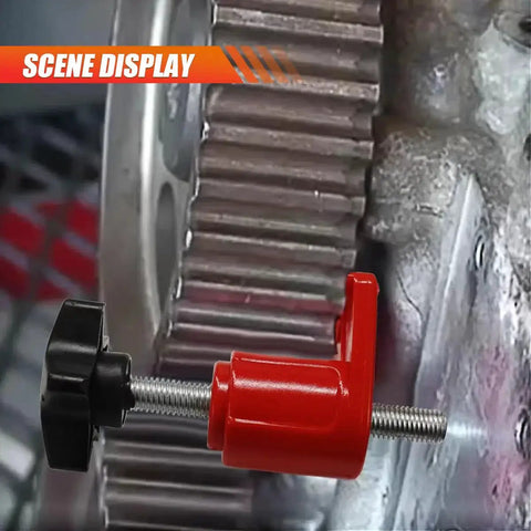 Automotive camshaft locking tool with red body and black knob, side view mounted on timing gear