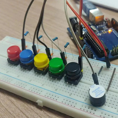 Colorful 12x12x7.3mm tactile push buttons on breadboard for Arduino projects, showing SMD PCB switches with caps, pack of 25 usage.
