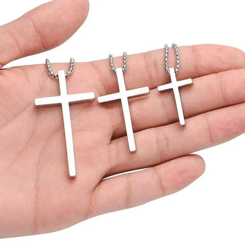 Hand holding Dope Silver Stainless Steel Cross Necklace for Men with 20 Inch Box Chain Pendant, hypoallergenic and lead free.