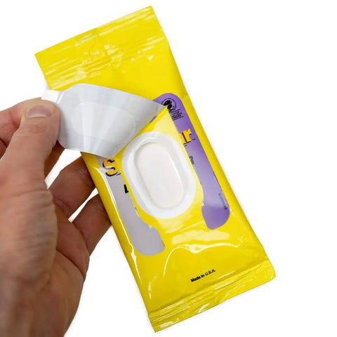 Hand opening yellow pack of Lens Cleaning Wipes For Glasses And Screens Streak Free Scratch Free 192 Wipes