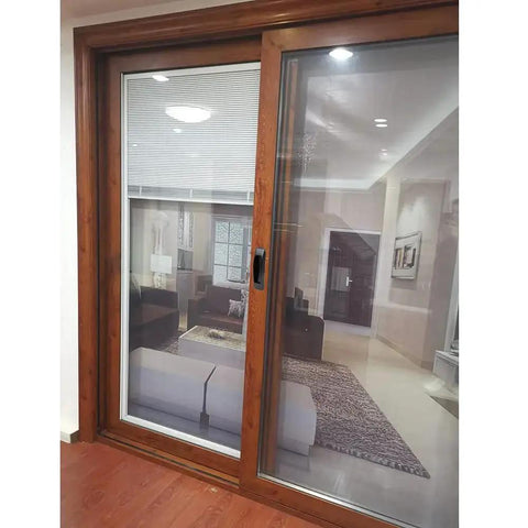Wooden framed sliding glass door with view of modern living room interior with furniture and decor.