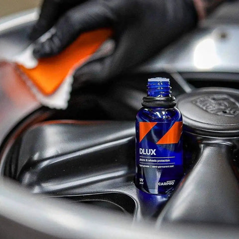 Close-up of DLUX Wheel and Trim Ceramic Coating 30mL with UV protection on alloy wheel, restores gloss and shields.