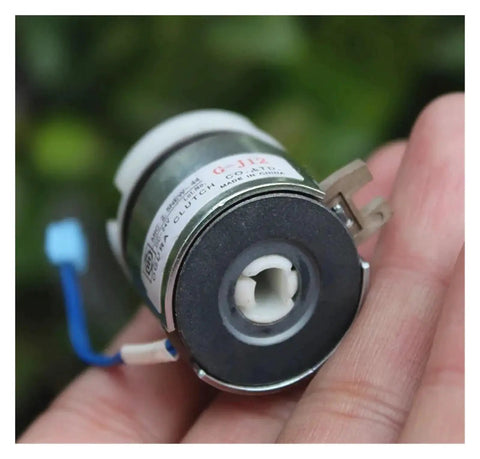 DC24V miniature electromagnetic clutch held by fingers; metal housing with a white plastic hub and blue wiring