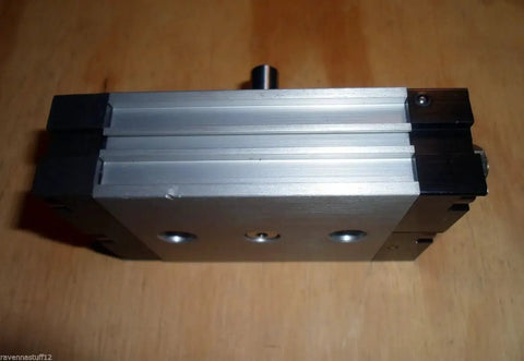 Front view of Smc Cdrqb 20 rotary air cylinder with silver aluminum body and black end caps.