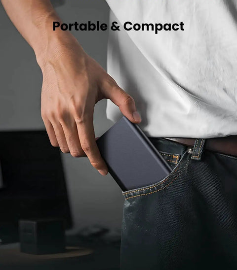 Person placing a portable hard drive into jeans pocket, demonstrating compact size for easy carrying.