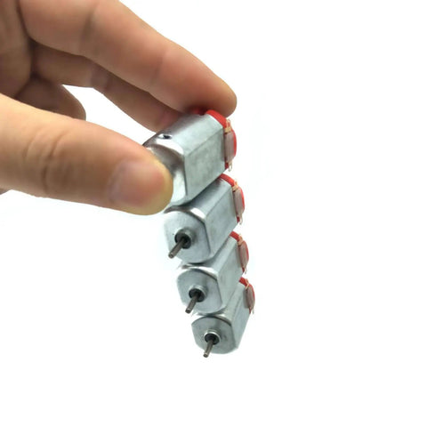 Hand holding stack of mini electric hobby motors from Six Pack DC Motors Kit For DIY Projects 3V To 12V Up To 25000 RPM