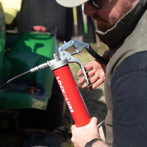 LockNLube heavy-duty pistol-grip grease gun with red metal body, silver lever, and inline hose.