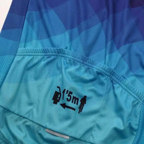Blue cycling jersey with gradient pattern and safety distance icon showing 1.5m