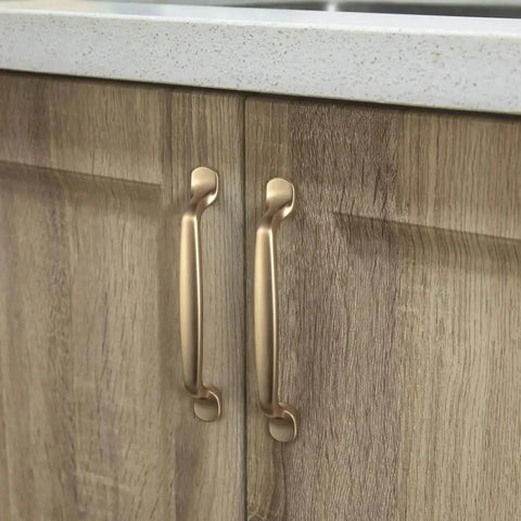Installed Six Pack 5 Inch Center To Center Arch Cabinet Pulls in champagne bronze finish on wooden kitchen cupboards